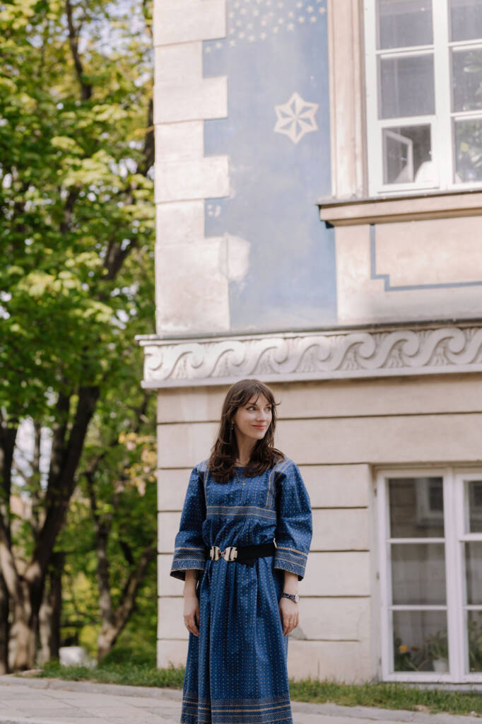 Portret w szerokim kadrze, architektura kamienicy w tle